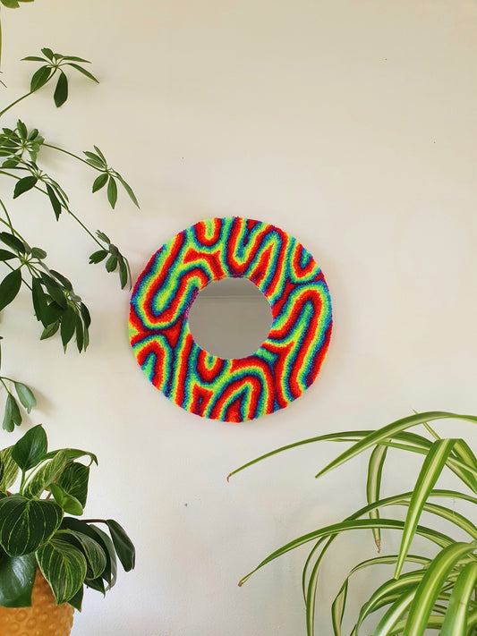 Miniature round psychedelic swirl mirror in rainbow with red and blue accents