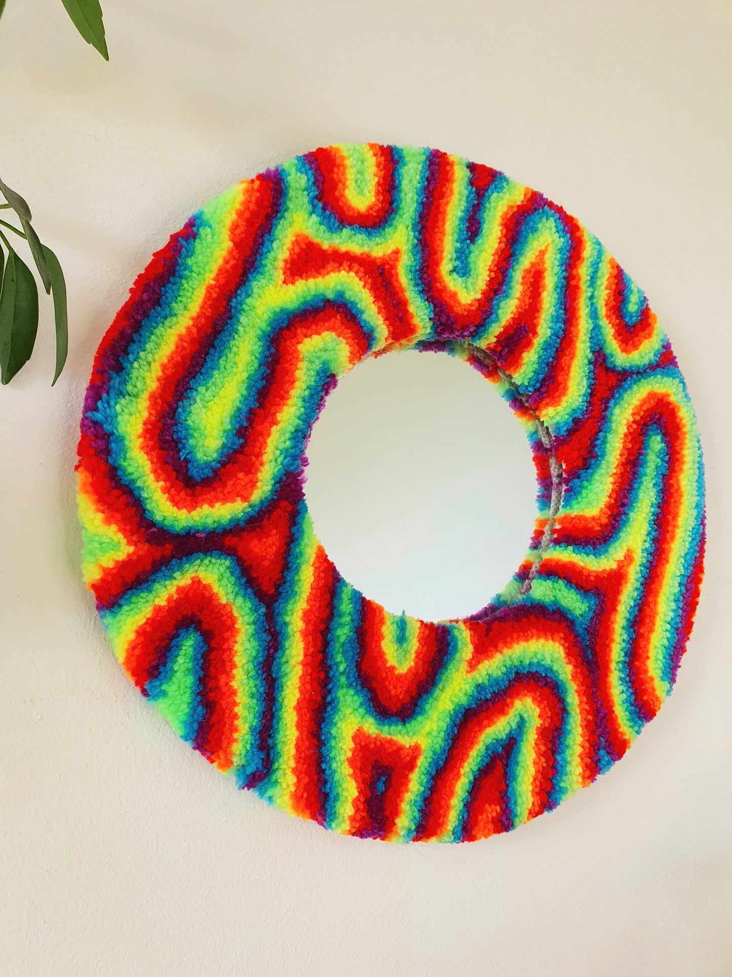 Miniature round psychedelic swirl mirror in rainbow with red and blue accents