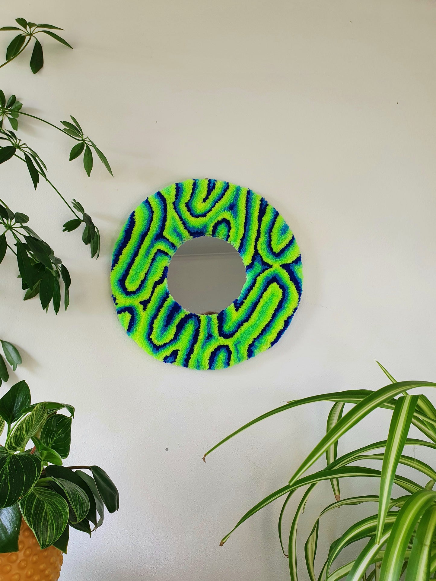 Miniature round psychedelic swirl mirror in greens and blues